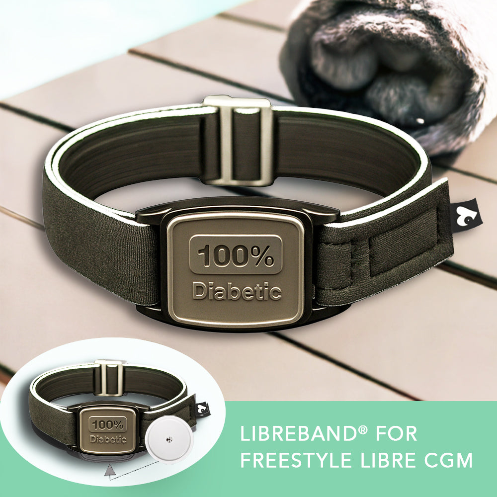 Armband with '100% Diabetic' label on a wooden surface, featuring the Libreband for Freestyle Libre CGM.