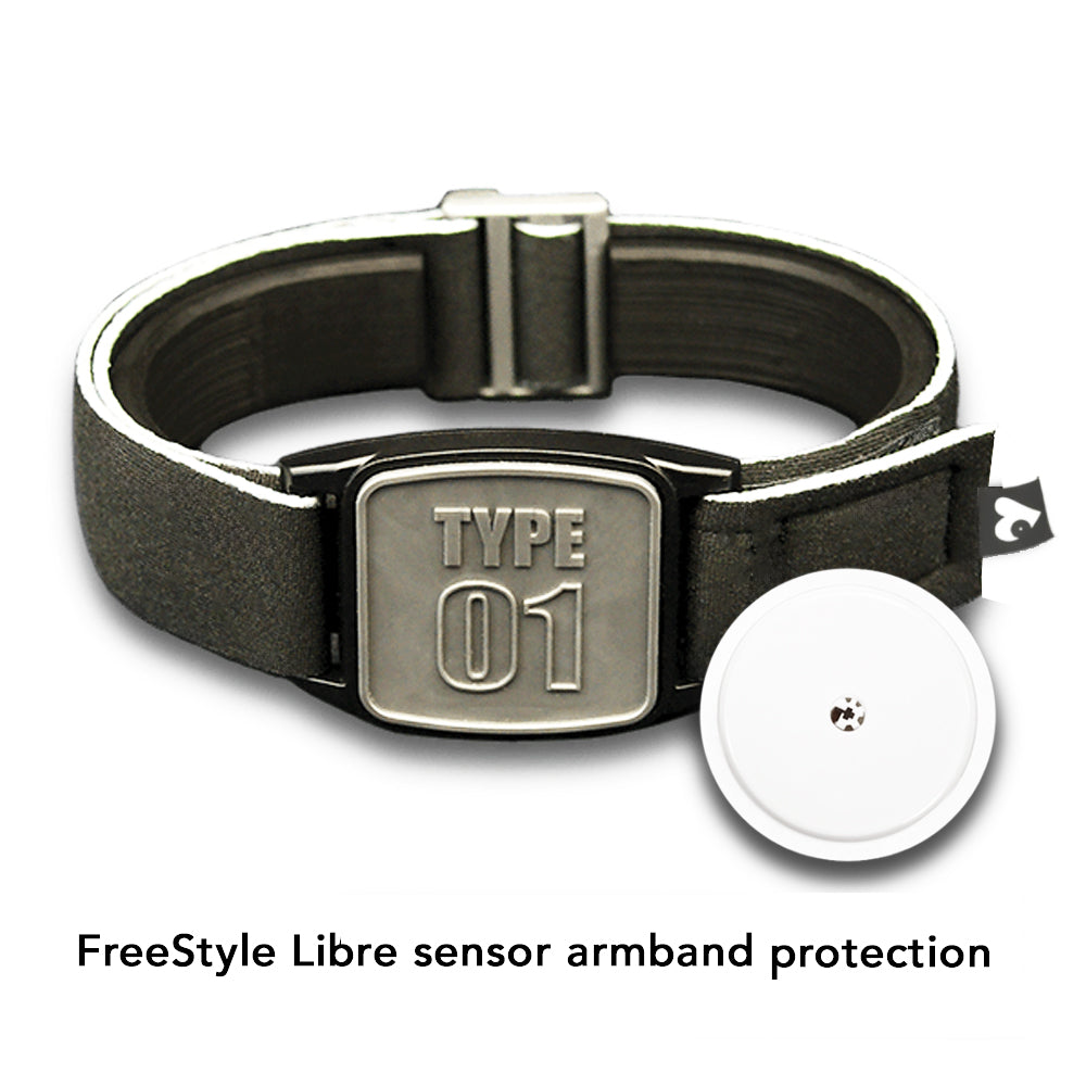 A pewter-type neoprene armband with a 'TYPE 01' design, intended for use with FreeStyle Libre 2 or Lingo CGM devices, displayed by a poolside.
