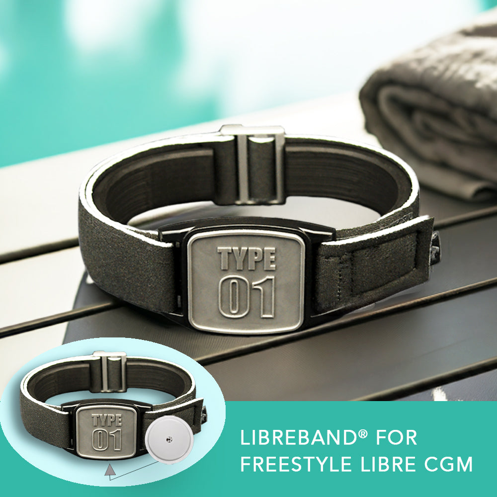 A pewter-type neoprene armband with a &#39;TYPE 01&#39; design, intended for use with FreeStyle Libre 2 or Lingo CGM devices, displayed by a poolside.
