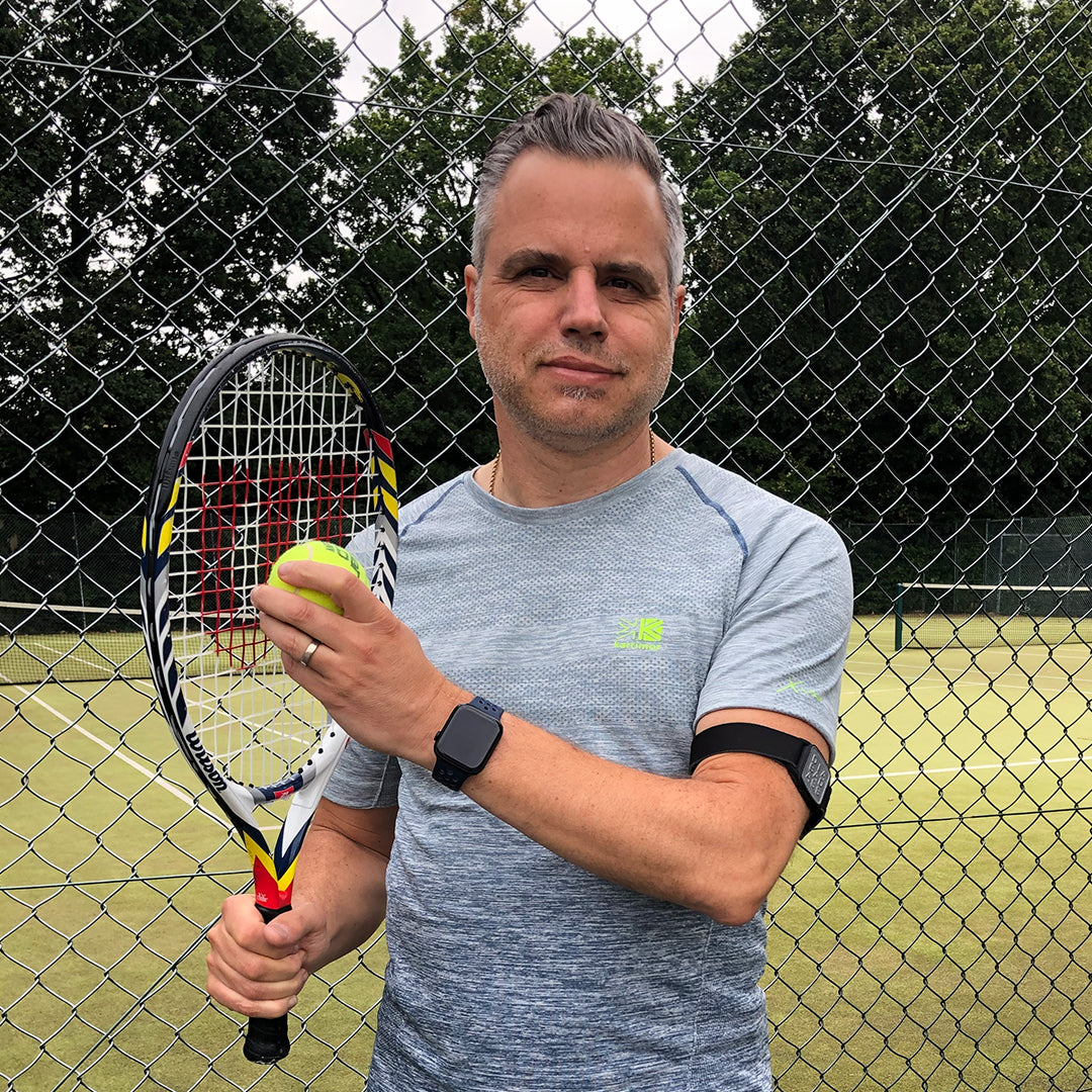 Model wearing pewter diabadass armband cover for Freestyle Libre 2 sensor, playing tennis.