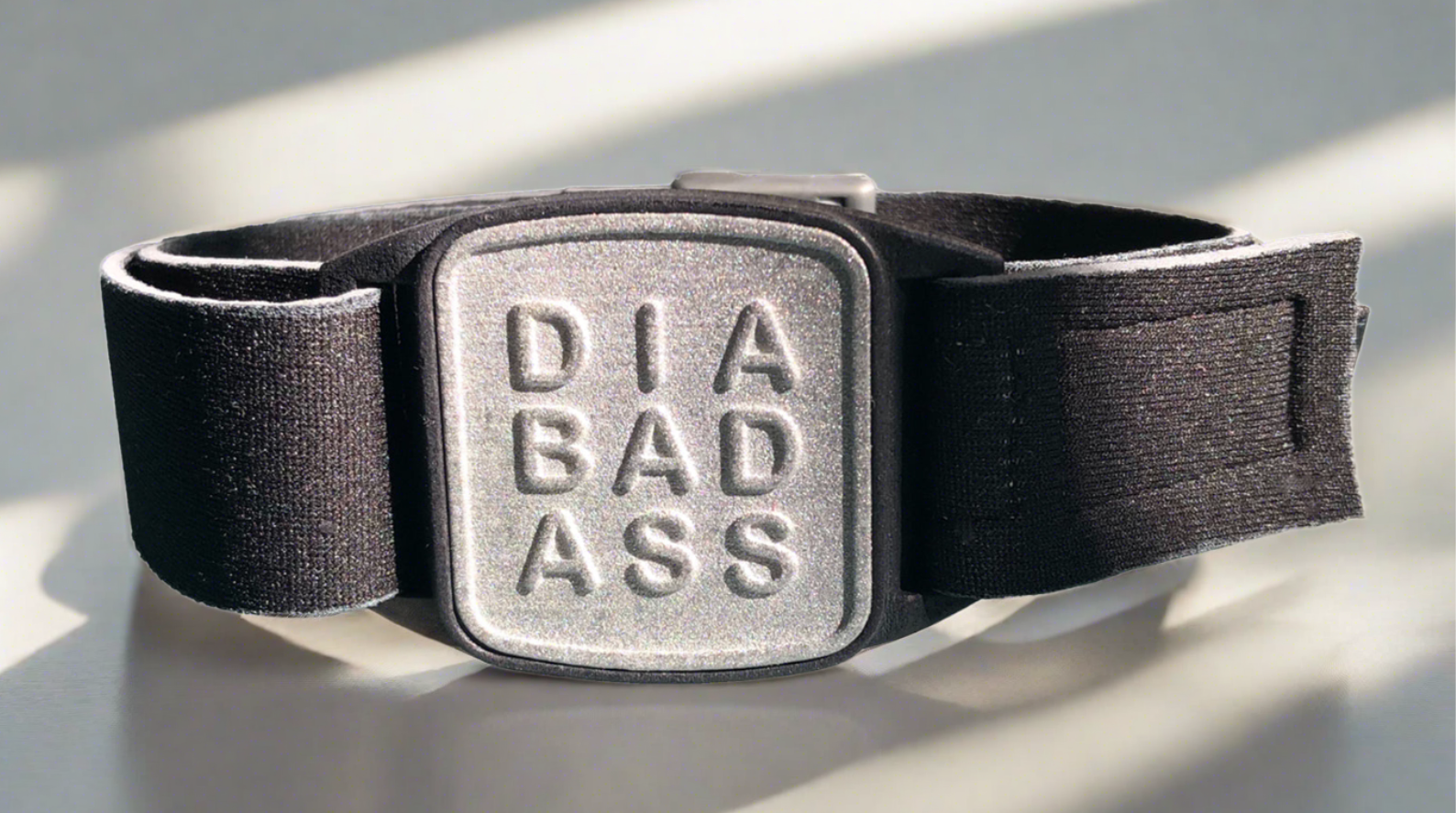 Dexband armband for Dexcom G7 CGM. Black strap with pewter DIABADASS cover.