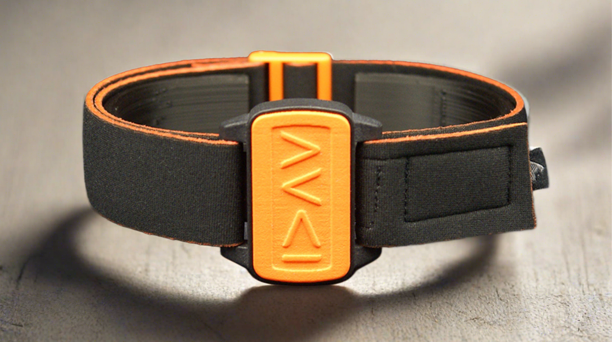 Dexband for Dexcom G6 sitting on wooden table, I am greater symbols on orange cover with black strap.