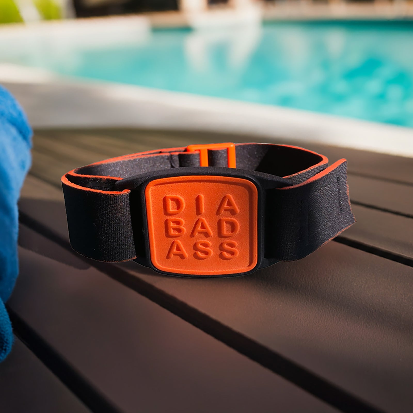 Dexband CGM armband for Dexcom G7 and ONE+ sensors with orange Diabadass cover and black neoprene strap in swimming pool setting