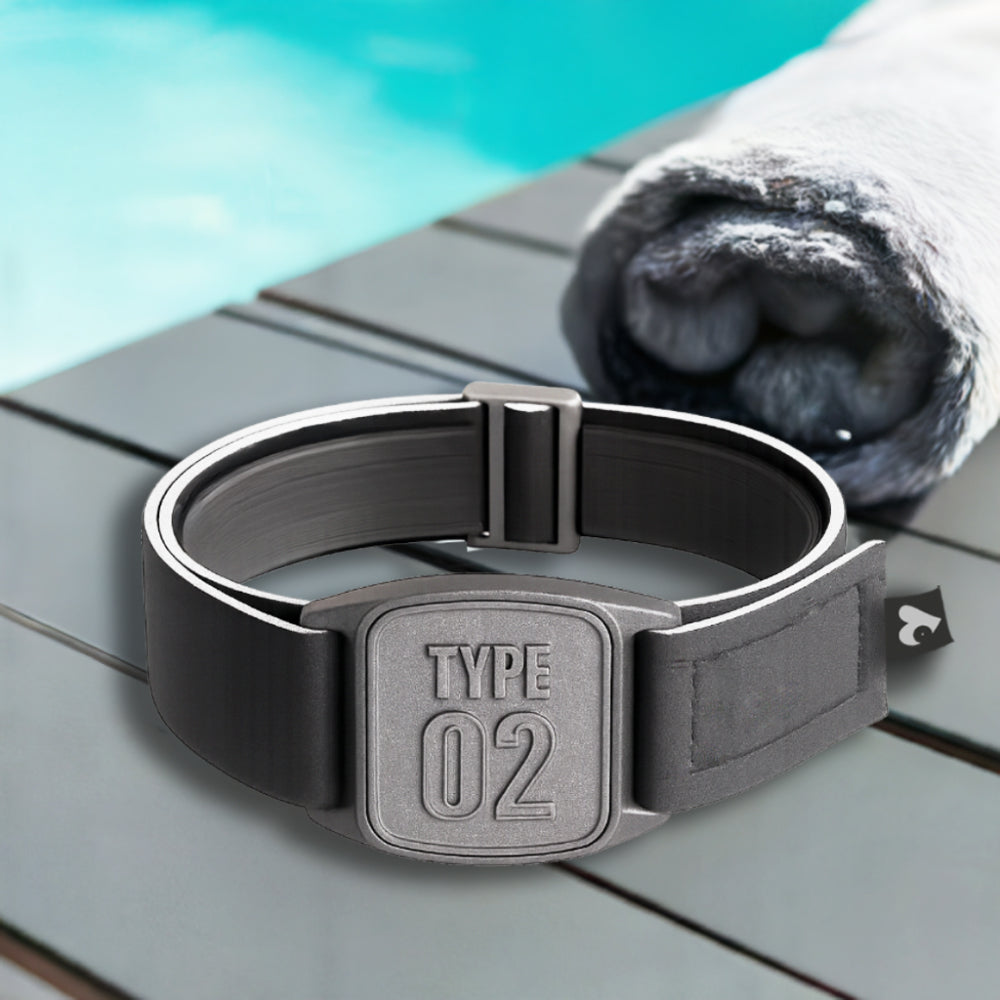 A pewter-colored neoprene armband with a &#39;TYPE 02&#39; design, branded as Love My Libre Ltd, intended for use with a Freestyle Libre CGM. The armband is displayed on a wooden surface with a pool in the background.
