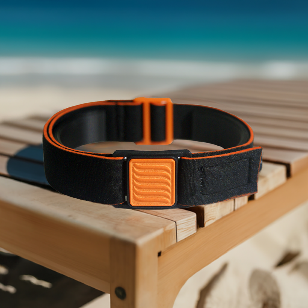 Libreband armband cover in orange and black, wave design. Shown in beach scene.