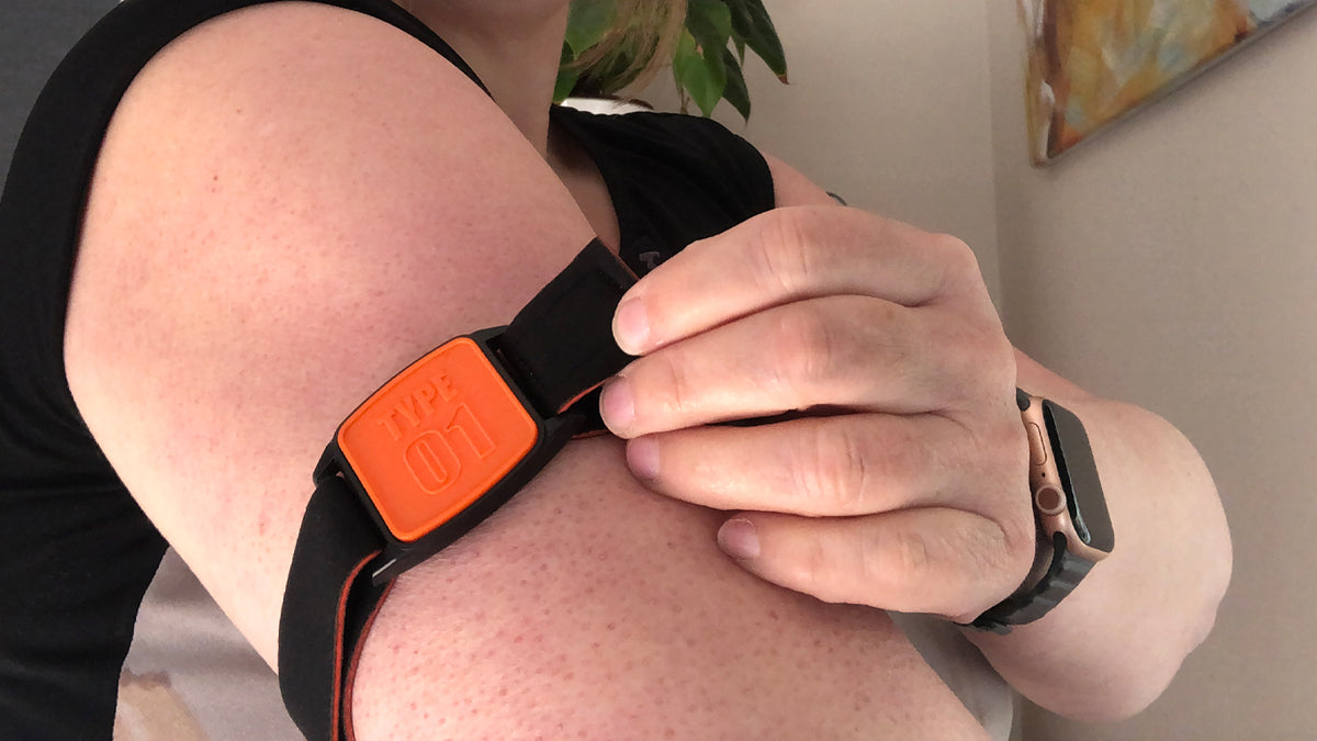 Model showing Libreband Armband for Freestyle Libre 1 &amp; 2. Orange cover with TYPE 01 design.