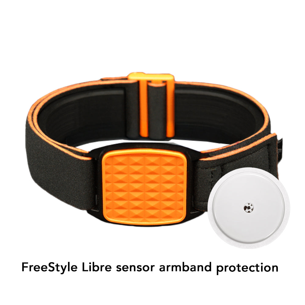 An orange and black Freestyle Libre 2 CGM sports armband with a pyramid design, placed on a wooden surface near a white towel.