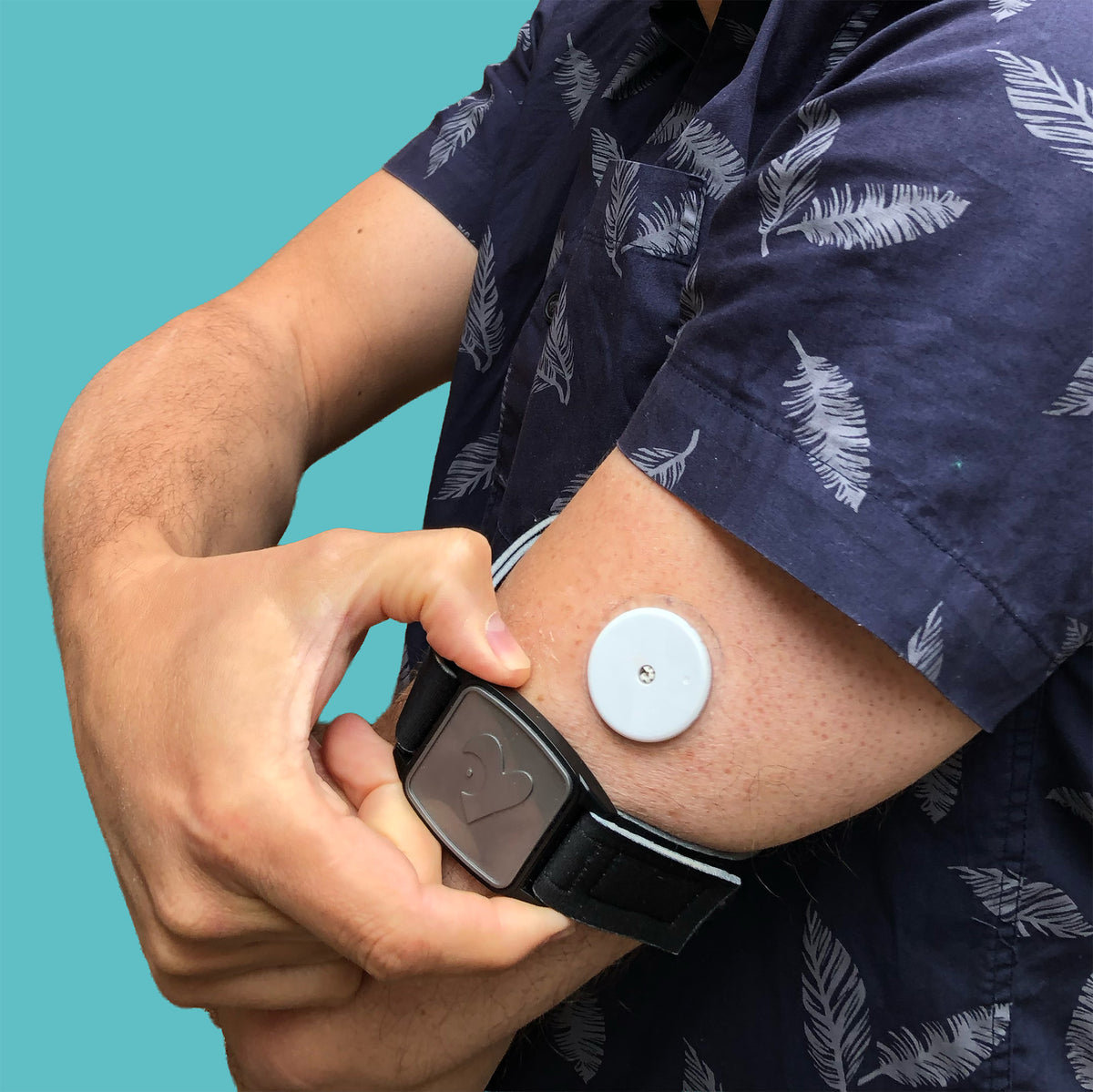 Libreband CGM armband for FreeStyle Libre 2 with pewter heart cover and water-resistant neoprene strap worn on upper arm. LML4627, LML2944, LML2579, LML2586.