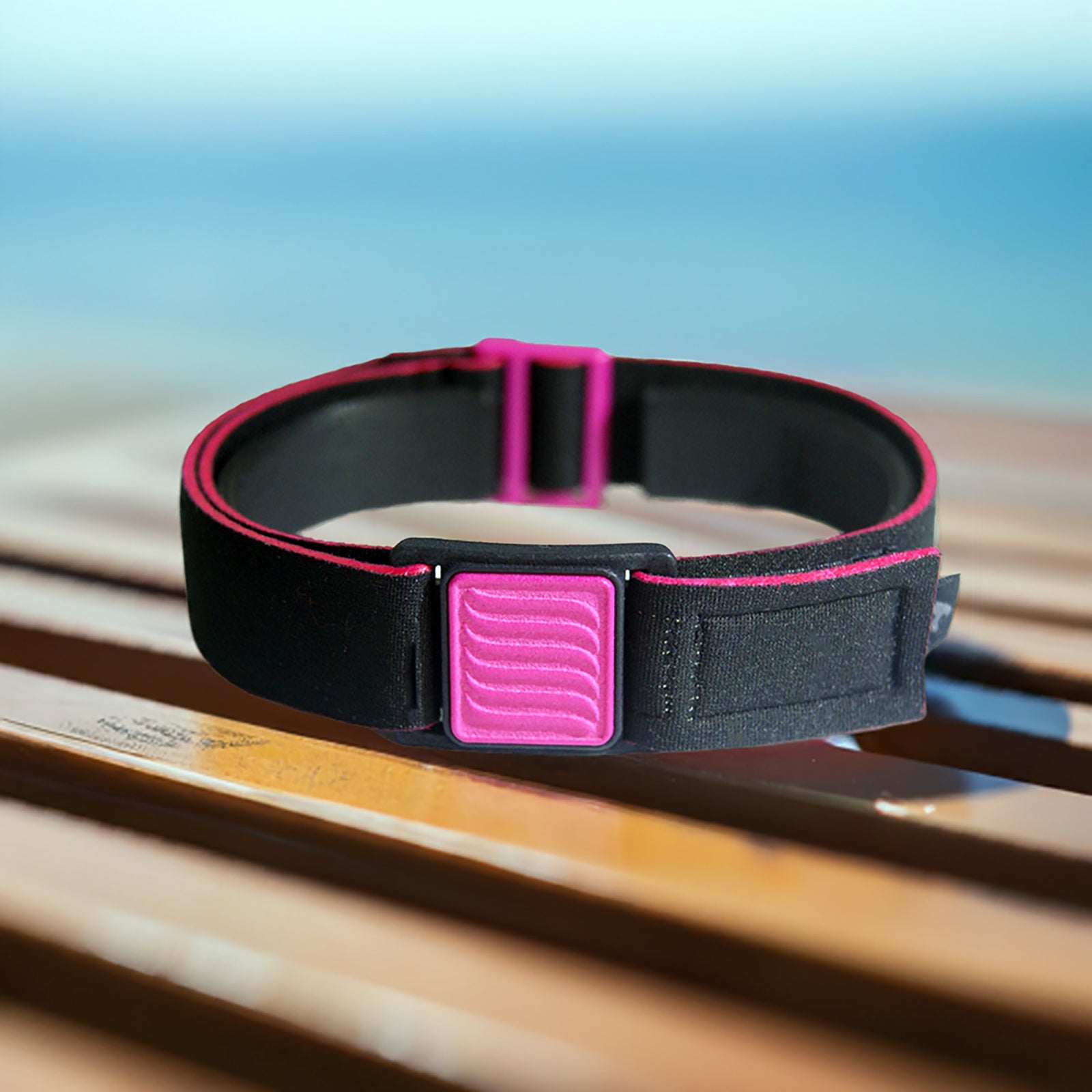 Libreband CGM armband for FreeStyle Libre 3 with magenta wave cover and black water-resistant neoprene strap on beach lounger.