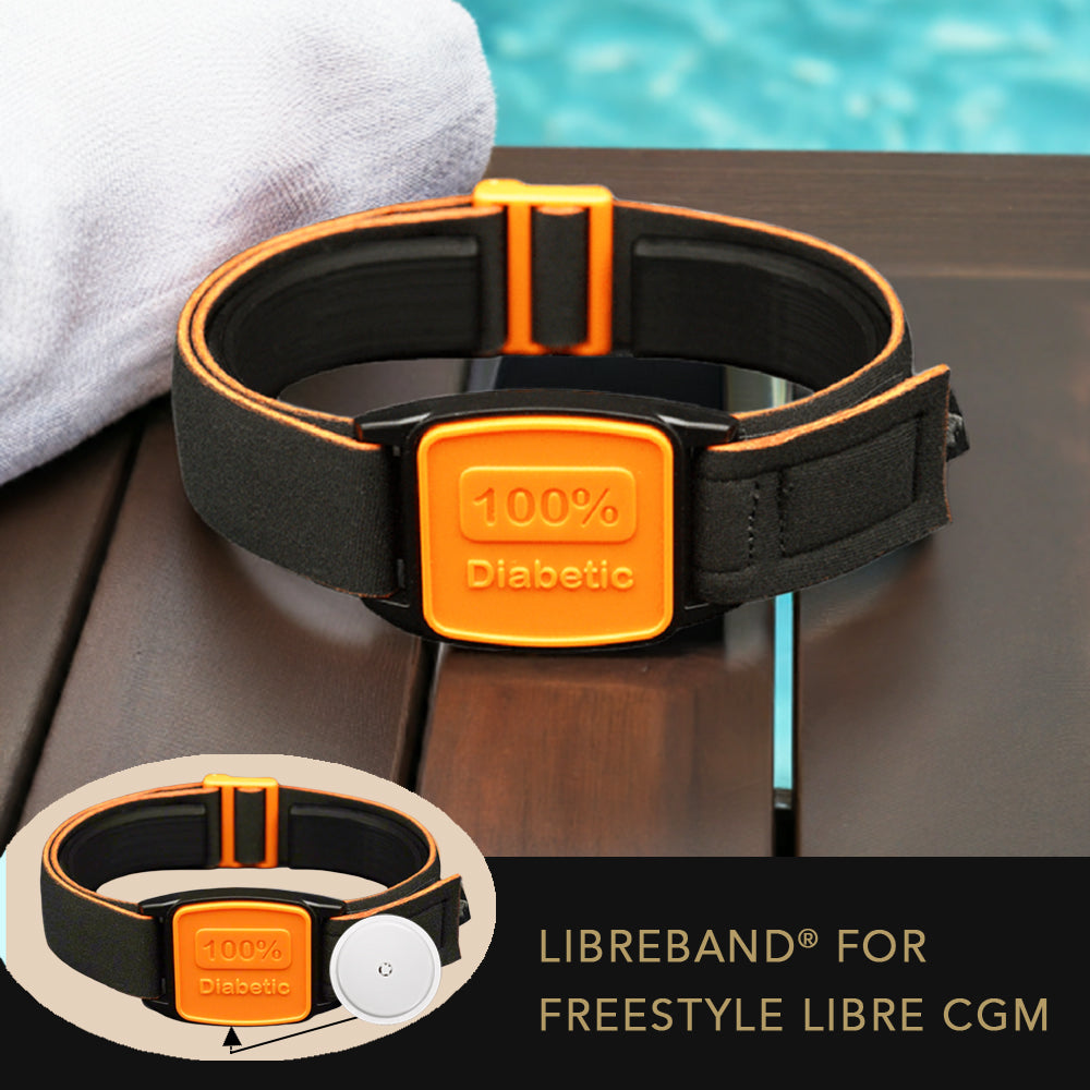 Black and orange Libreband for Freestyle Libre CGM on a wooden surface with a pool in the background.